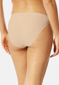 Beige Unterwäsche mit hohem Bund aus glattem, dehnbarem Stoff. Verfügt über ein nahtloses Design mit einem weichen elastischen Bund und vollständiger Abdeckung.