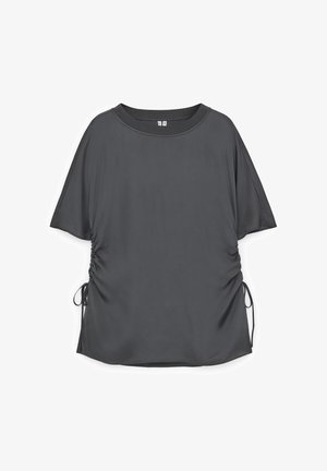 Mørkegrå kortærmet damebluse med rund halsudskæring og justerbar sidesmøg, der bindes med tynde snore.