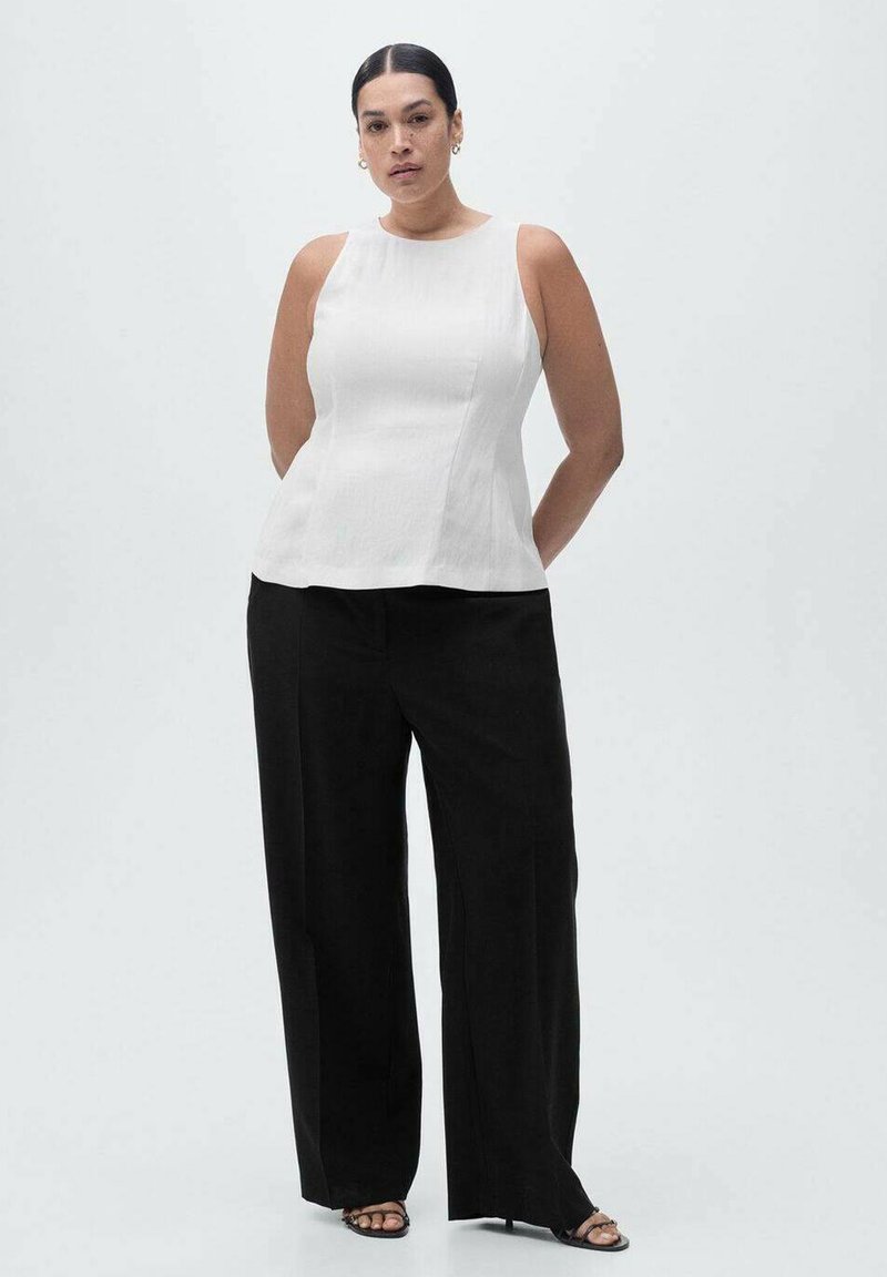 Top alb fără mâneci, cu o siluetă ajustată, din țesătură texturată; asortat cu pantaloni negri evazați, cu talie înaltă și sandale negre.