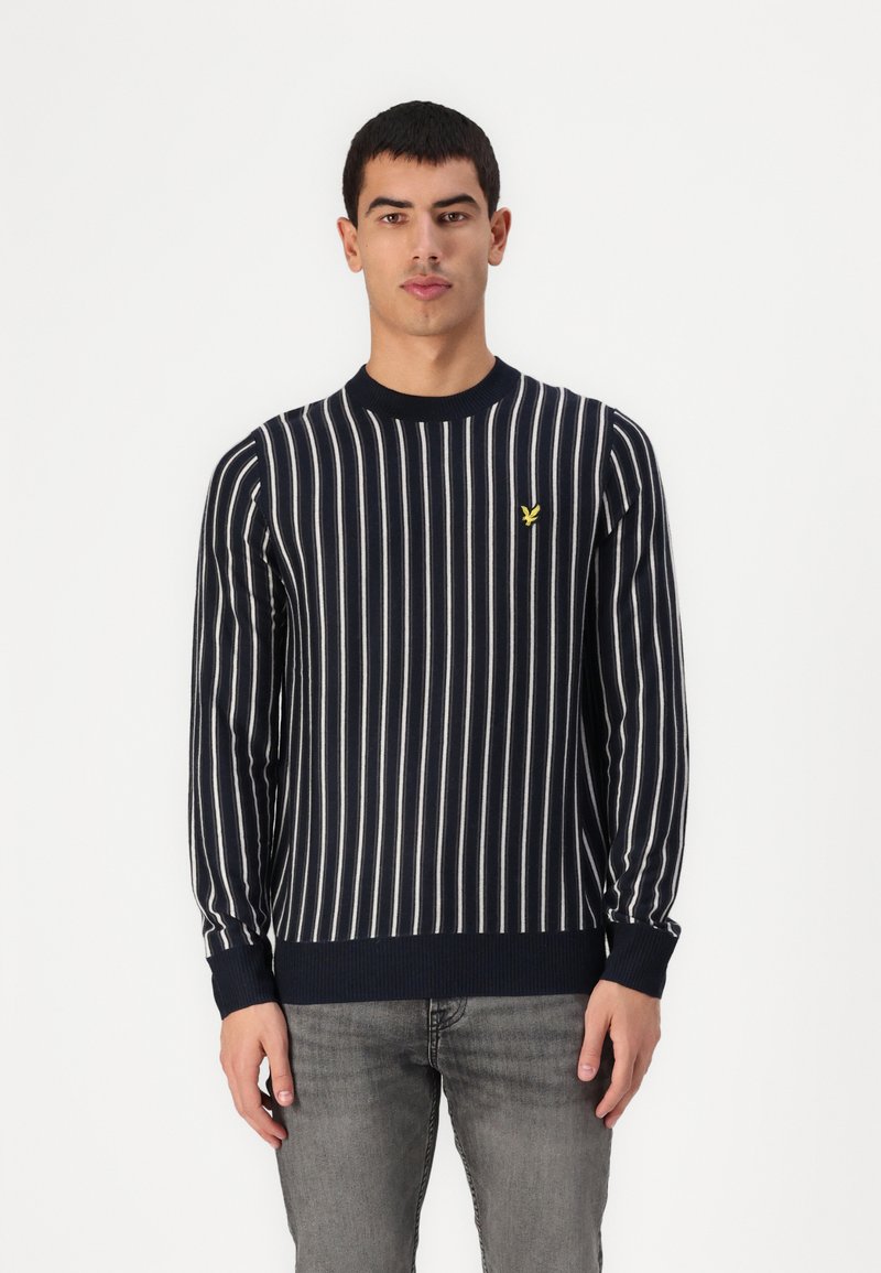 Marineblauer Strickpullover mit vertikalen weißen Streifen, geripptem Rundhalsausschnitt und Bündchen, mit einem kleinen gelben Logo auf der linken Brust.