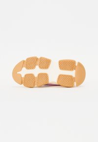 La suola della sneaker presenta gomma con un motivo a spina di pesce, di colore marrone chiaro e un design segmentato per migliorare la trazione e la flessibilità.