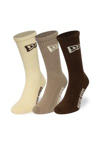 Set bestehend aus drei Socken in Creme, Taupe und Braun. Baumwollmischung, geribbelte Textur, mit Logo-Akzenten in kontrastierenden Farben nahe der Oberseite.
