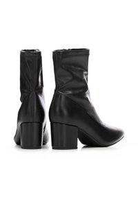 Paire de bottes en cuir noires mi-mollet avec talons carrés, fermetures éclair latérales, et bouts arrondis sur fond blanc.