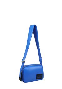 Borsa a tracolla rettangolare blu brillante con tracolla imbottita e regolabile e patch logo "Studio Berlin" nero sul davanti.