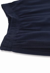 Tessuto blu navy con una superficie liscia, caratterizzato da dettagli arricciati lungo il bordo, tagliato in un design piegato.