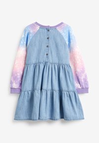Robe en denim avec un design à volants, corps bleu et manches en tie-dye violet et rose. Comprend une fermeture à boutons à l'arrière et un col côtelé.