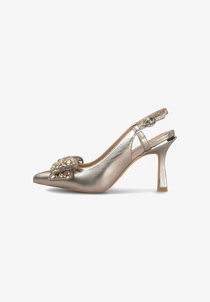 Sandal de tacón alto en dorado metálico con punta afilada, detalle de hebilla ornamentada y un diseño de tacón delgado. Textura suave y forma elegante.