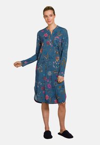 Floral-printed long-sleeve dress in blue fabric, with a buttoned neckline, side slits, and a relaxed fit. Non-slip black slipper shoes.