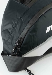 Black nylon shoulder bag with a sleek, angular design, featuring a textured strap and a prominent white logo and zippers.