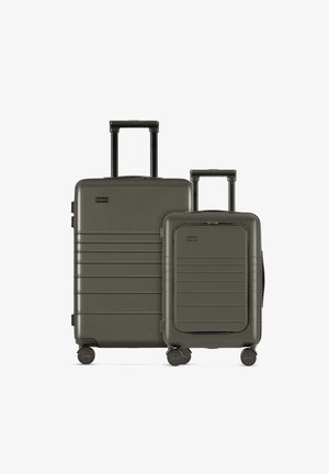 Zwei olivgrüne Hartschalenkoffer, einer größer mit horizontalen Rillen und einem Teleskopgriff, sowie eine kleinere Version mit ähnlichen Designdetails.