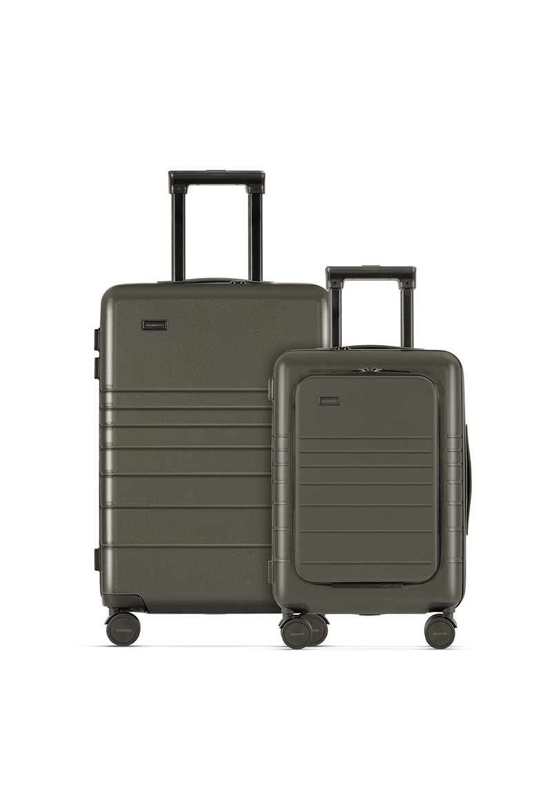 Zwei olivgrüne Hartschalenkoffer, einer größer mit horizontalen Rillen und einem Teleskopgriff, sowie eine kleinere Version mit ähnlichen Designdetails.