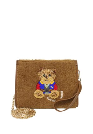 Borsa in finta pelliccia marrone con un orsetto ricamato in un outfit blu e rosso, con una tracolla in catena dorata e il dettaglio "RUE MAPI PARIS".
