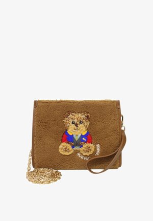 Borsa in finta pelliccia marrone con un orsetto ricamato in un outfit blu e rosso, con una tracolla in catena dorata e il dettaglio "RUE MAPI PARIS".
