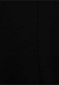 Schwarzer Strickstoff mit einer glatten Textur, der ein gleichmäßiges Rippenmuster und minimale Nähdetails entlang der Kanten zeigt.