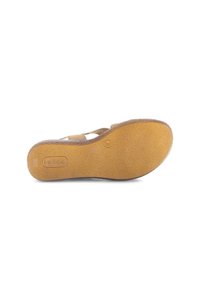 Tan flat sandal with textured rubber sole, featuring an embossed logo and a smooth upper design. The heel is low and practical for ease of wear.