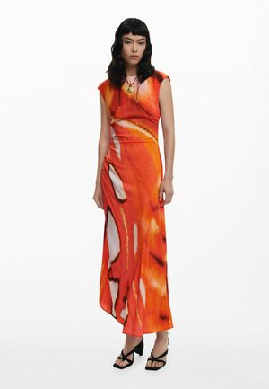 Long, orange dress with abstract, wave-like patterns. Features short cap sleeves, a fitted bodice, and a flowing skirt. Black strappy heels.