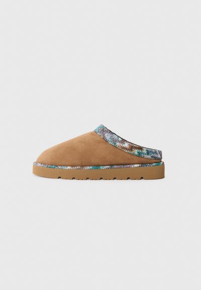 Brązowe zamszowe buty typu slip-on z kolorową wzorzystą kołnierzem i ozdobnym przeszyciem. Gumowa podeszwa z detalami zapewniającymi przyczepność.