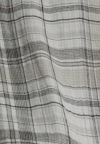Woven fabric w jasnoszarym tle, z czarno-białym wzorem w kratę, o miękkiej teksturze oraz widocznych liniach poziomych i pionowych.