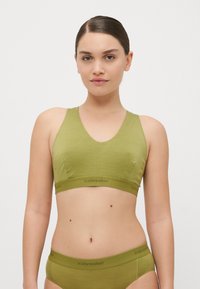 Bralette verde-azeitona com decote em V, alças largas, construção sem costuras e uma banda elástica com marca na bainha.