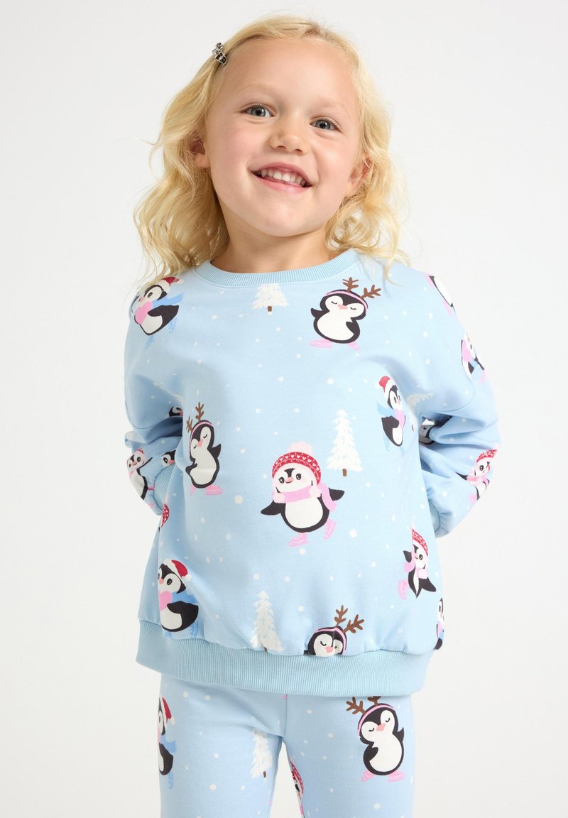 Light blue children's sweatshirt and pants set featuring playful penguin patterns, snowflakes, and holiday accents. Soft, comfortable fabric.