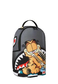 Zaino dalla forma arrotondata, in tessuto grigio, con un cartone animato di un gatto arancione sorridente con un design di bocca a denti aguzzi nella parte inferiore.