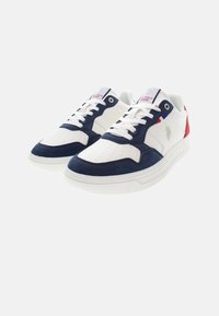 Zapatillas deportivas blancas con detalles en azul marino y rojo, materiales de cuero y ante, con perforaciones y una suela de goma texturizada.