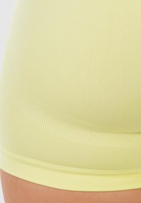 Geel naadloze shorts met een gladde textuur, voorzien van een geribde tailleband en een slim fit ontwerp. De stof lijkt lichtgewicht en rekbaar.
