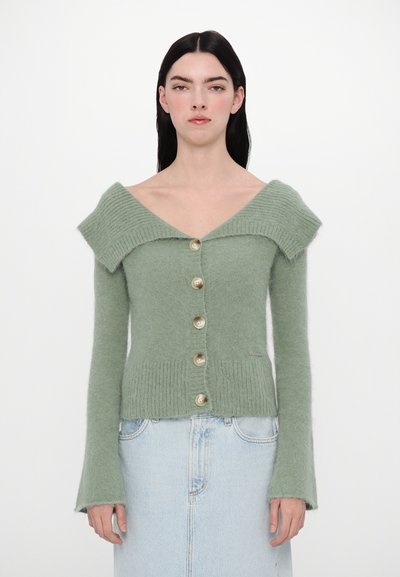 Světle zelený pletený cardigan s výstřihem do V a převislým límcem, který má pět velkých knoflíků, žebrovaný lem a nabírané rukávy.