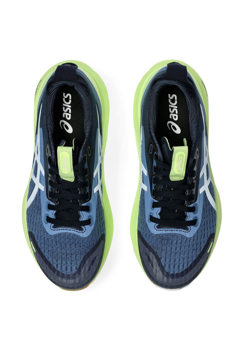 Blauwe en marineblauwe sport schoenen met groene accenten, bovenwerk van mesh, textuur oppervlak, wit logo en donkere veters. Kenmerkt een gewatteerde zool.