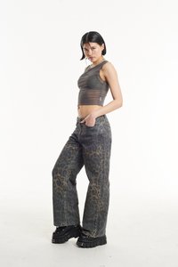 Top corto gris semitransparente combinado con jeans de leopardos de corte holgado; unos zapatos de plataforma negros y gruesos completan el atuendo.