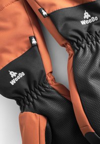 Vattentäta handskar med en övre del i orange och en svart texturerad underdel. Har elastiska muddar och en liten logotag.