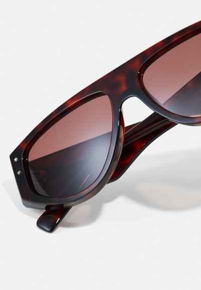 Tortoiseshell sunglasses with large, angular frames and dark pink lenses. Features silver accents on the frames and a glossy finish.
