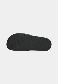 Semelle de chaussure en caoutchouc noir avec un motif de relief texturé et un logo en relief. Bords lisses avec un design arrondi, idéal pour un usage décontracté.