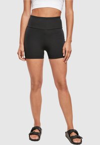 Black high-waisted active shorts with a smooth, stretchy fabric and a fitted design. The shorts feature a clean hem and minimal seams.