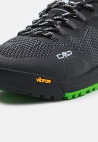 Czarny but sportowy z teksturowaną cholewką z siateczki, szarymi akcentami i zieloną podeszwą Vibram. Posiada wzmocniony czubek oraz odblaskowe sznurówki dla lepszej widoczności.