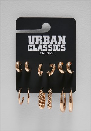 Ensemble de six paires de boucles d’oreilles créoles dorées de styles variés, présentées sur une carte noire de la marque Urban Classics libellée onesize.