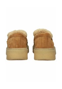 Brown suede slip-on shoes with a fluffy tan lining and a textured, light-colored sole. Features minimal stitching and no visible hardware.