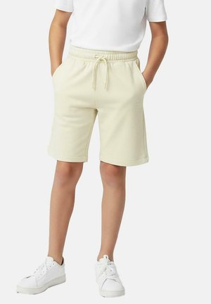 Beige fleece shorts met een elastische tailleband, trekkoord, zijzakken en een geborduurd logodetail, gecombineerd met witte sneakers.