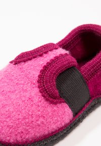 Vilt slipper in roze en donker bordeaux met een gestructureerd oppervlak, elastische zijpaneel en donkergrijze buitenzool. Rond neust ontwerp.