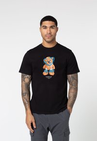 Black cotton t-shirt featuring a cartoon bear graphic in orange and blue, with the text "MILANO." Includes short sleeves and a crew neckline.