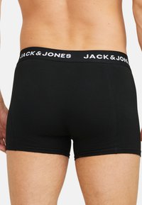 Zwarte boxershorts van zacht materiaal, met een snug fit en een contrasterend wit "JACK & JONES" logo op de tailleband.