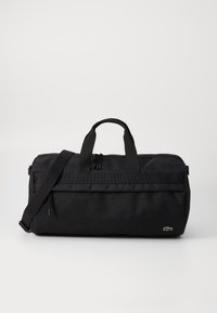 Bolsa de deporte negra hecha de tela duradera, con dos asas, una correa de hombro desmontable y un pequeño detalle del logo en el lateral.