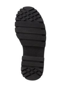Suela de zapato de goma negra con una superficie texturizada que presenta ranuras horizontales y verticales para tracción y estabilidad.