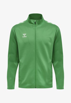Grøn sportjakke lavet af glat materiale med høj krave, fuld lynlås og hvide accentstriber på skuldrene. Hummel-logo vist.