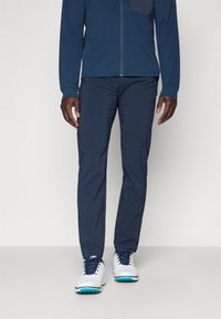 Navy blue athletic pants with a slim fit, crafted from lightweight material. Features a smooth texture and no visible patterns or accents.