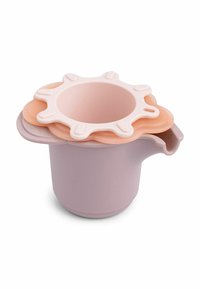 Stacked pastel silicone lids shaped like flowers on a lavender plastic measuring cup with a spout, set against a white background.