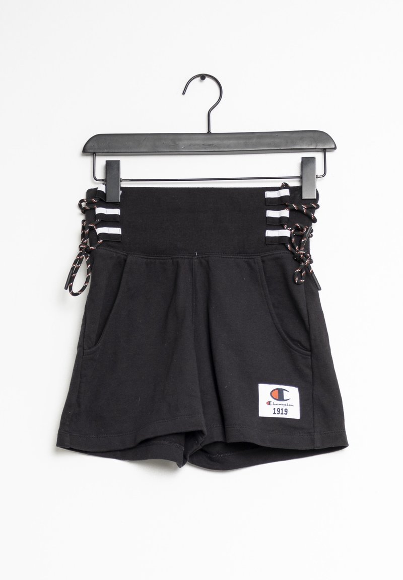 Short noir taille haute avec détails lacés sur les côtés, bandes blanches, poches avant et patch logo Champion 1919 sur l'ourlet, suspendu à un cintre noir.