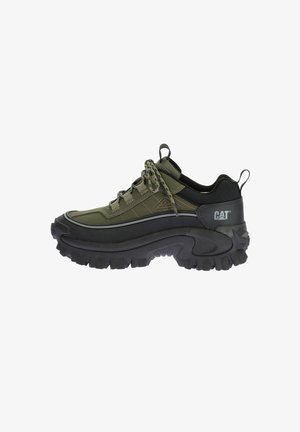 Sneaker impermeabile verde con suola nera spessa, tomaia texturizzata e striscia a contrasto. Presenta lacci e una linguetta sul retro. Marchio CAT visibile.