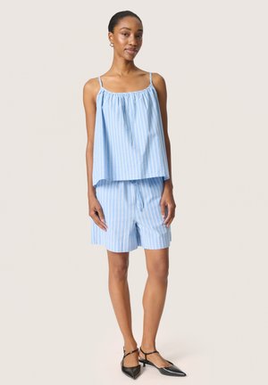 Débardeur rayé bleu clair à coupe ample, associé à un short assorti. Le matériau semble respirant, avec des bretelles fines et un design décontracté.