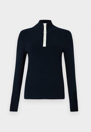 Haut à manches longues bleu marine avec une fermeture éclair crème contrastante sur un quart de longueur. Tissu doux et lisse avec une coupe ajustée.
